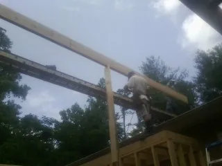 Carpenter setting a ridge beam over a new addition frame — Ice Dam Removal by Roofing Brothers in Saint Louis